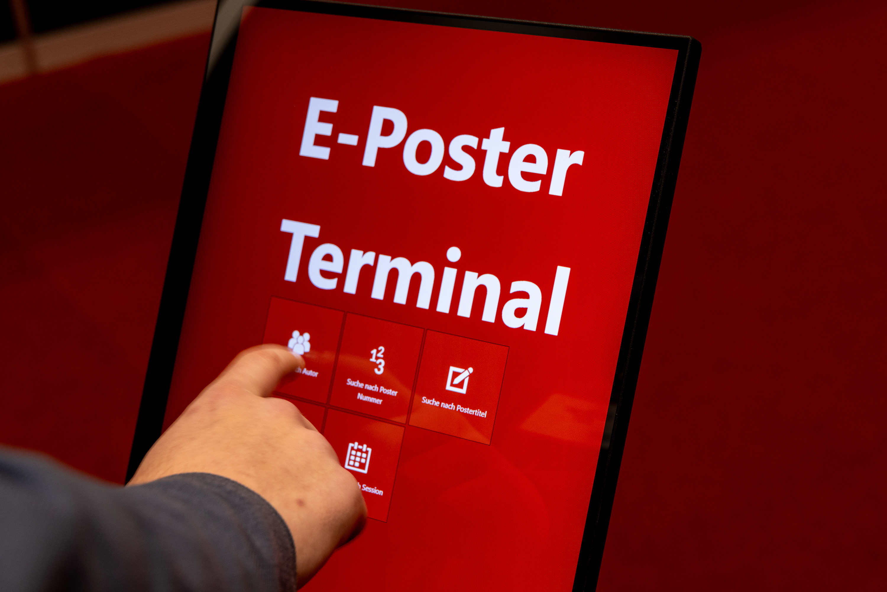red ePoster terminal closeup with hand 3.000 x 2.001